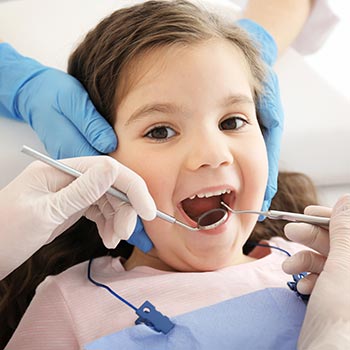Little girl getting teeth examined